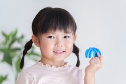 MRC矯正の器具を手に持つ女の子
