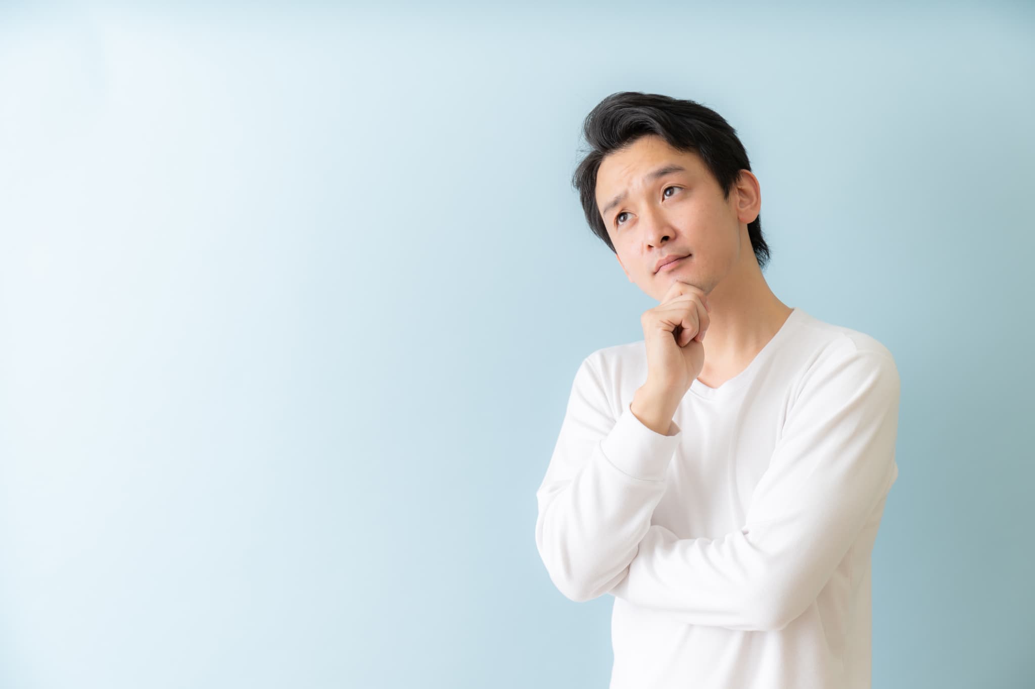 インプラント治療はどうして費用が高いのか考える男性