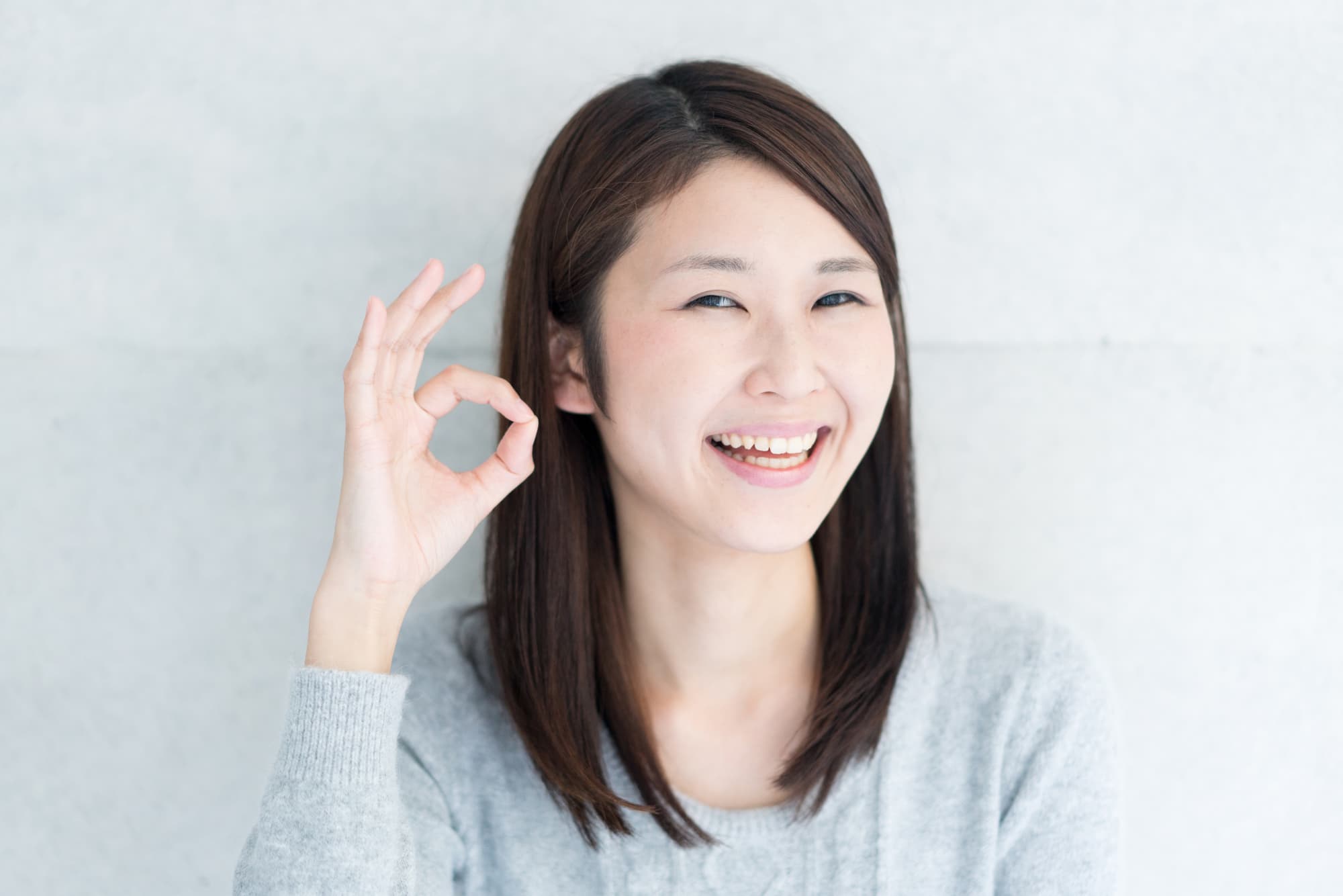 指でOKサインを出す女性