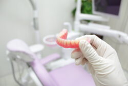 入れ歯を持った歯科医の手