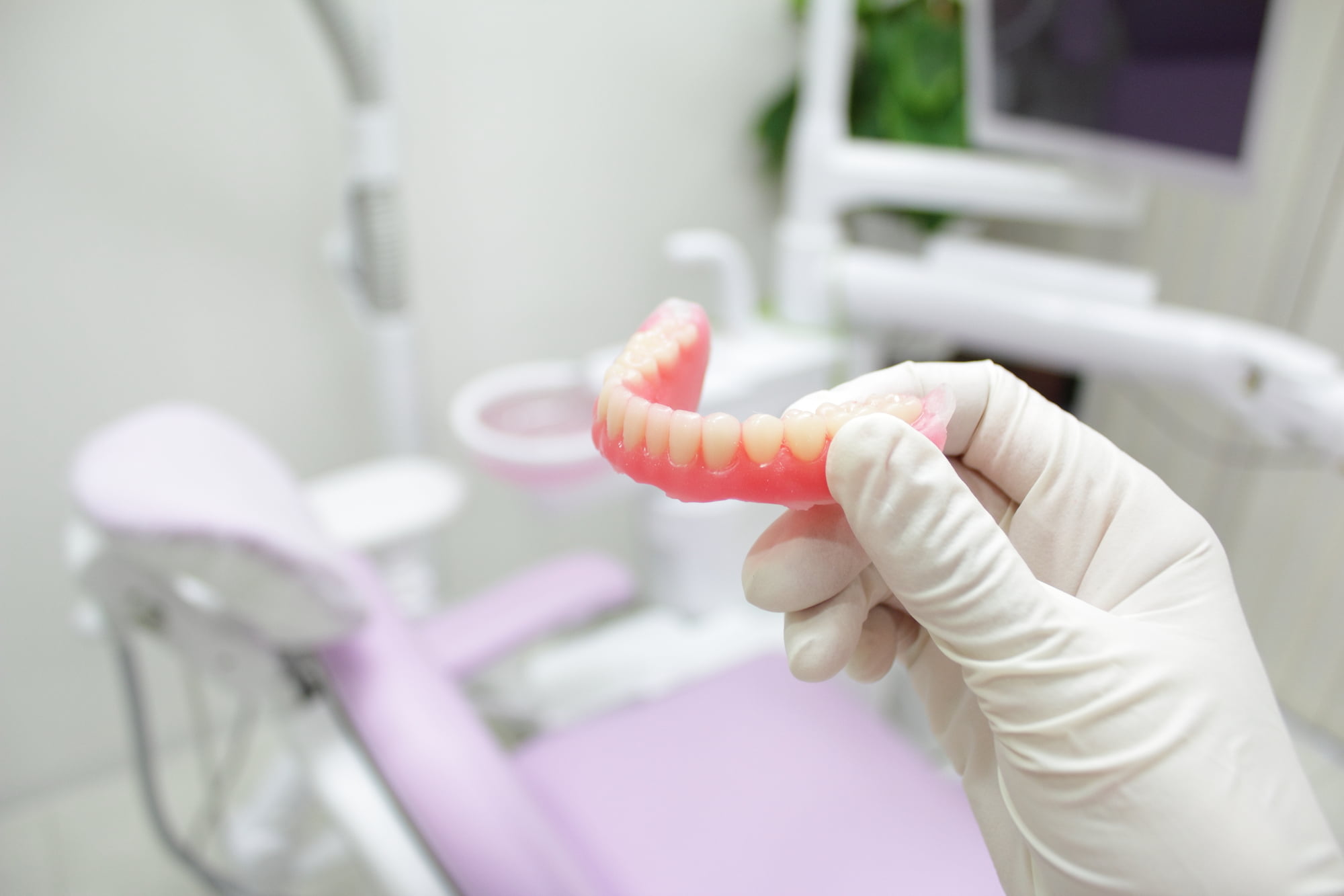 入れ歯を持った歯科医の手