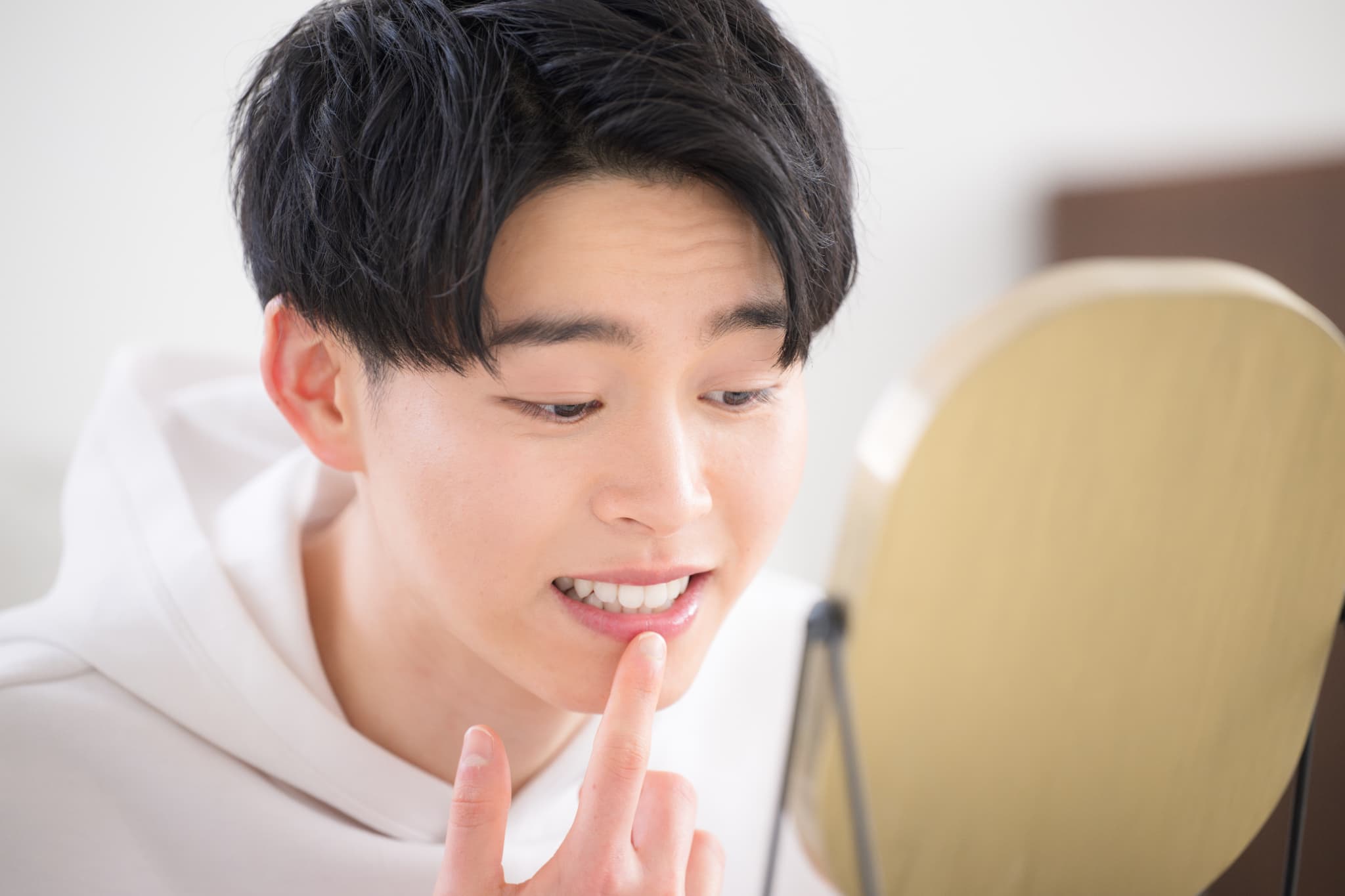 後戻りを気にして鏡をみる男性