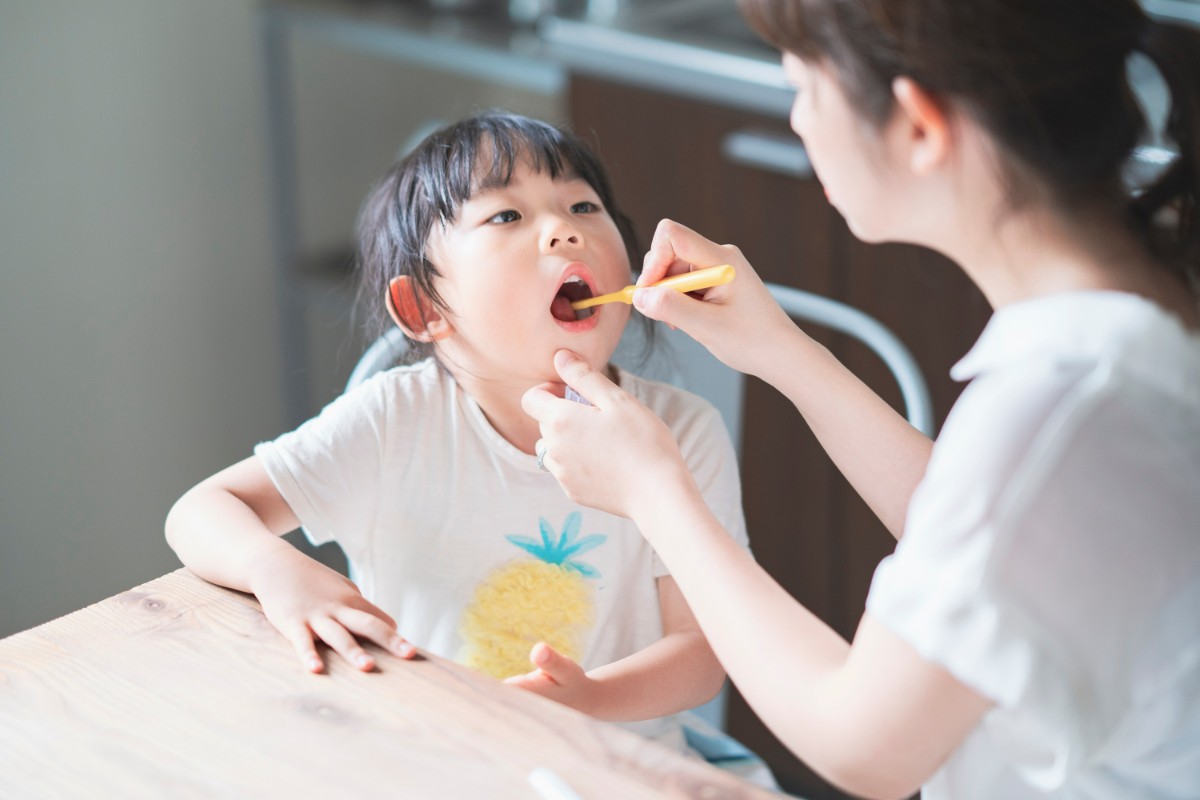 子どもに歯磨きをしてあげる親